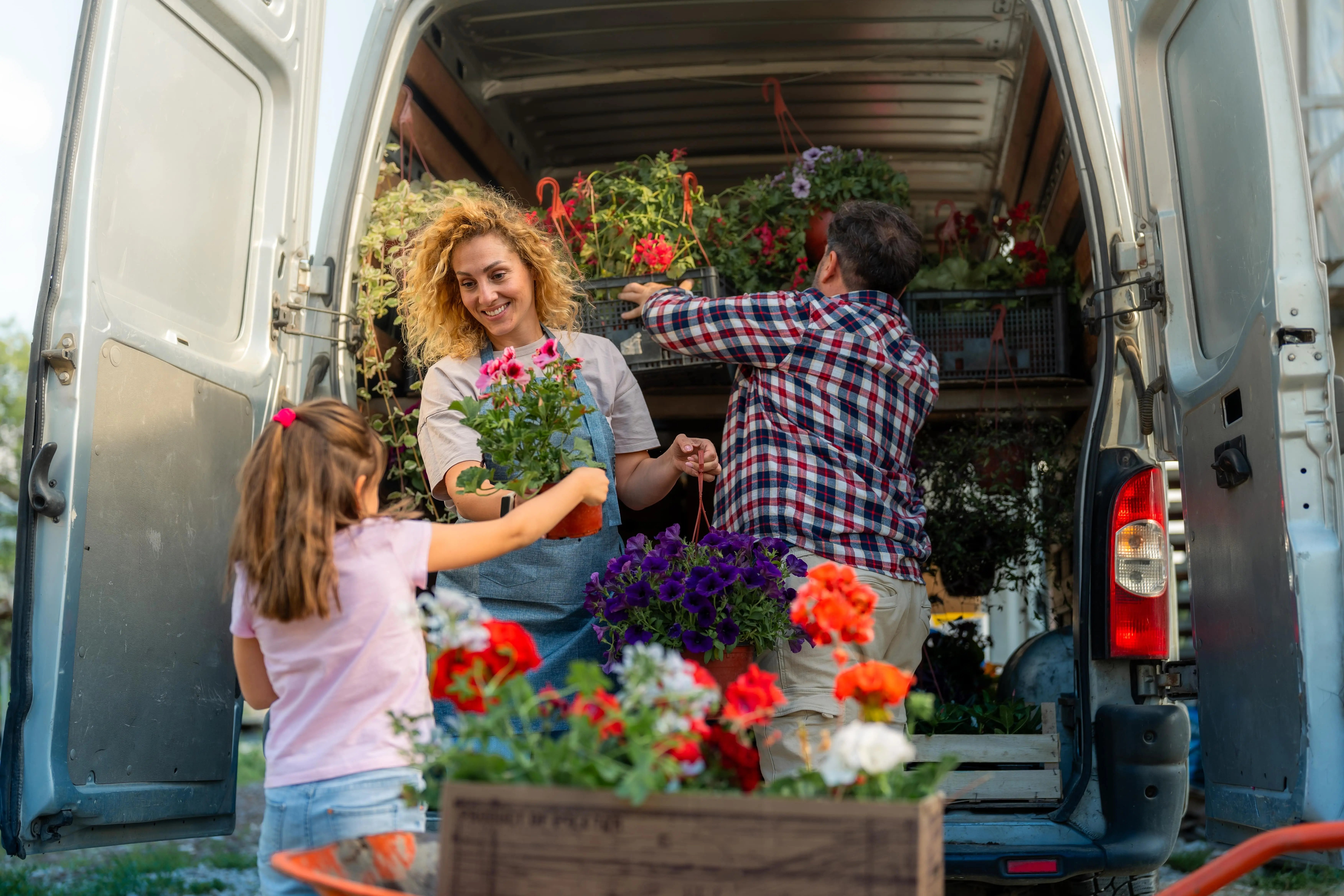 Young entrepreneurial women and family conducting business and managing flower boxes to be delivered with a commercial van rental