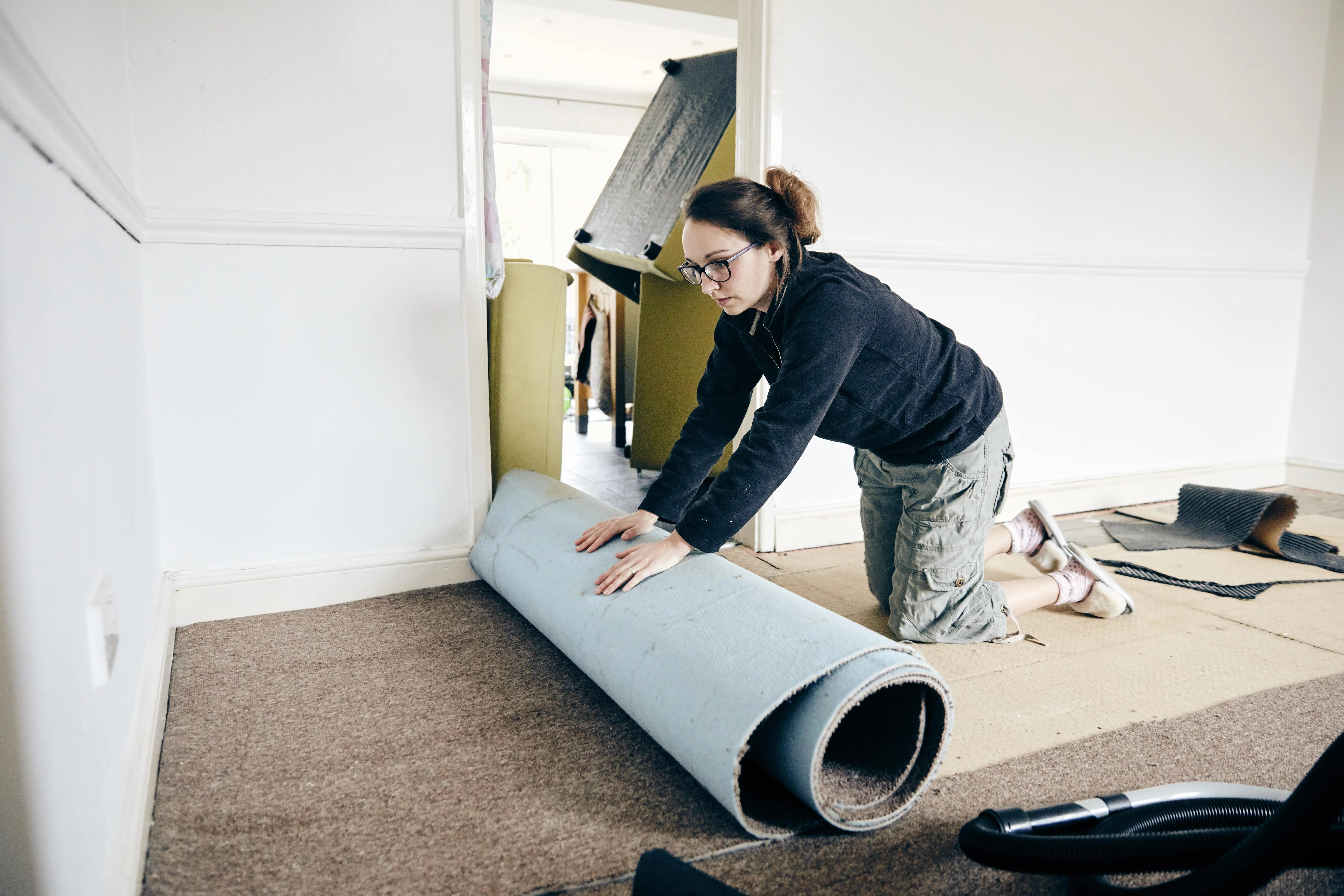 Woman laying new carpet during DIY Carpet replacement.