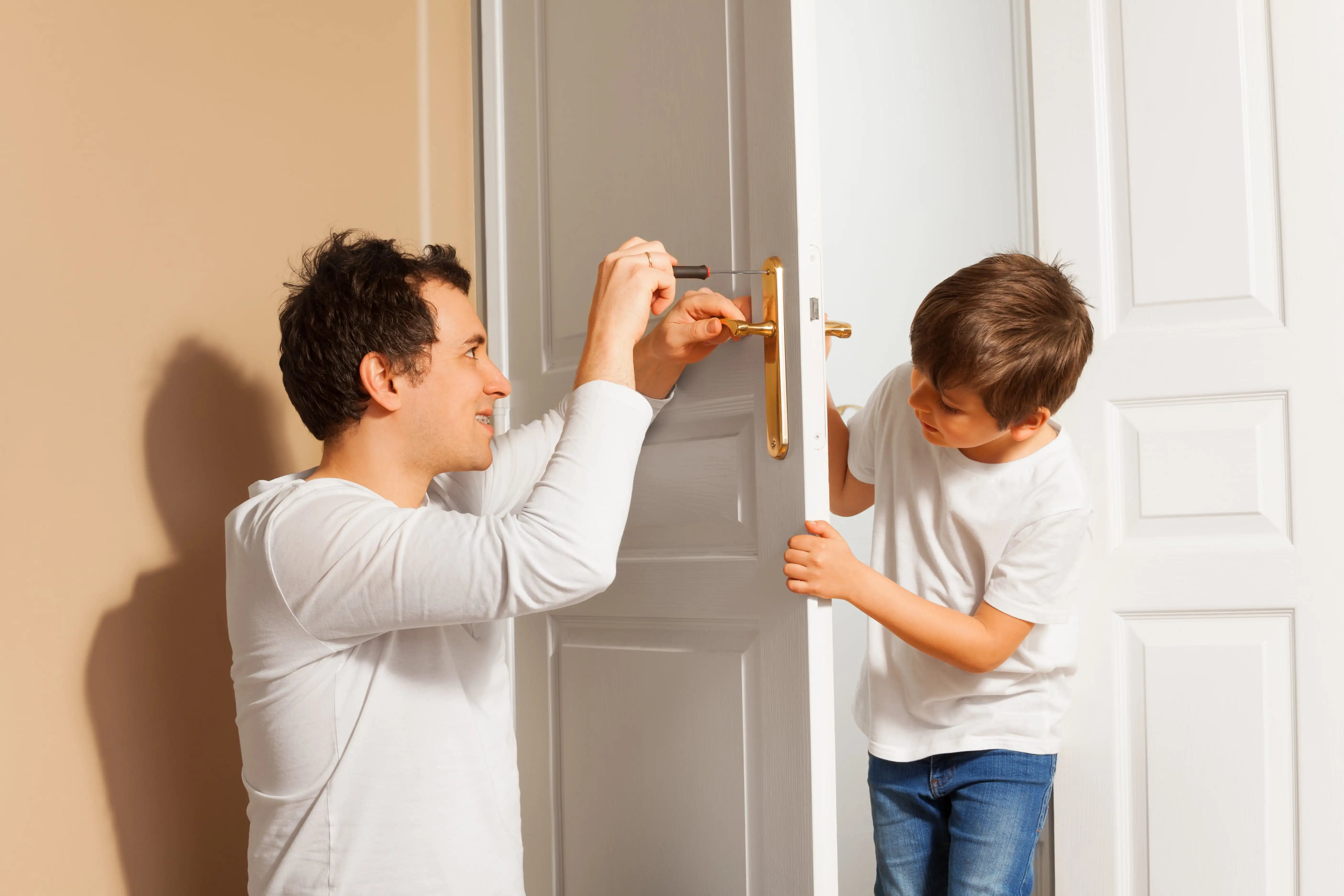 Father and son completing a DIY door installation with a self drive van hire.